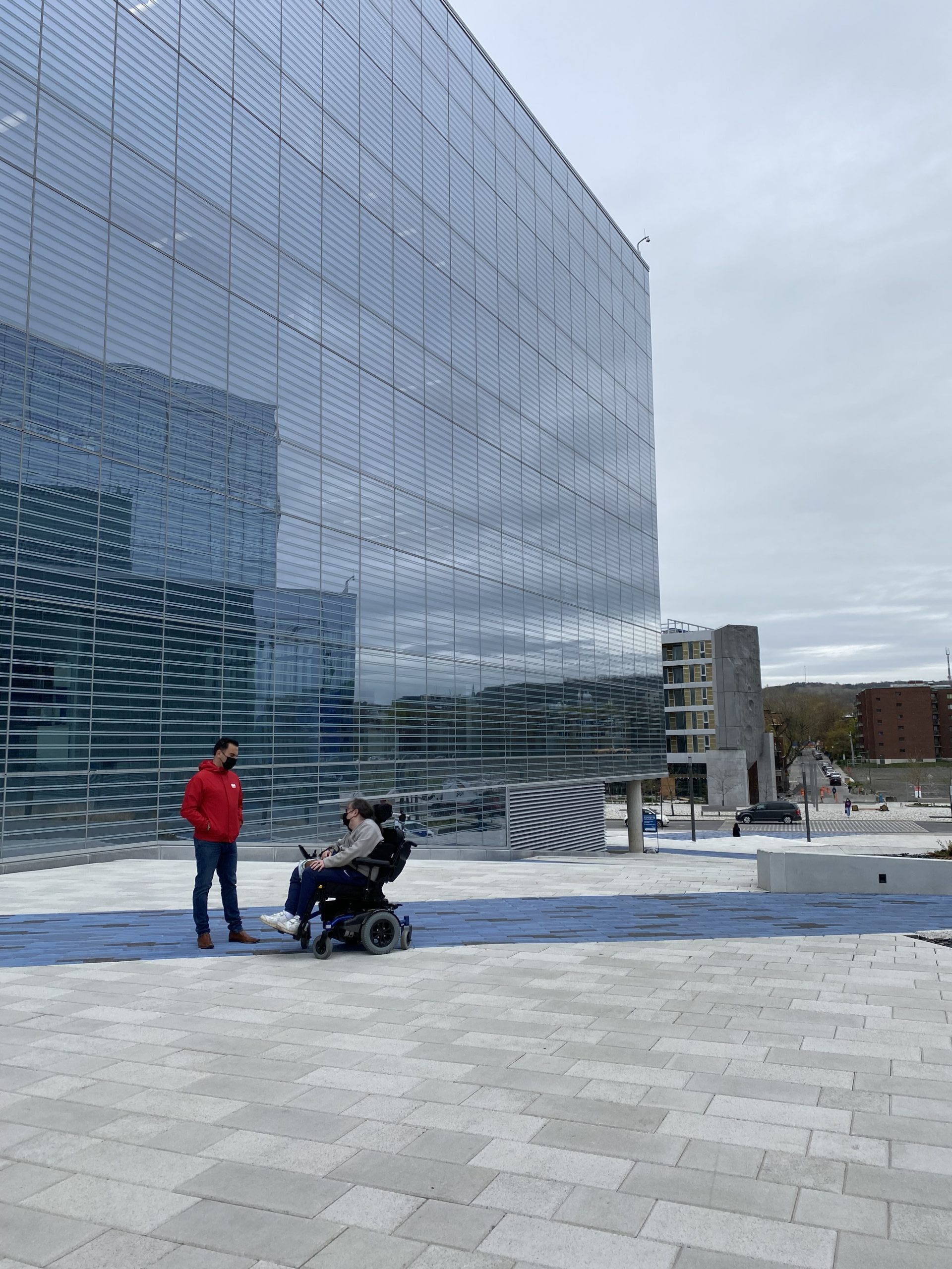 Description de l'image : Sébastien Richer et le professeur David London devant un pavillon vitré de l'Université de Montréal.